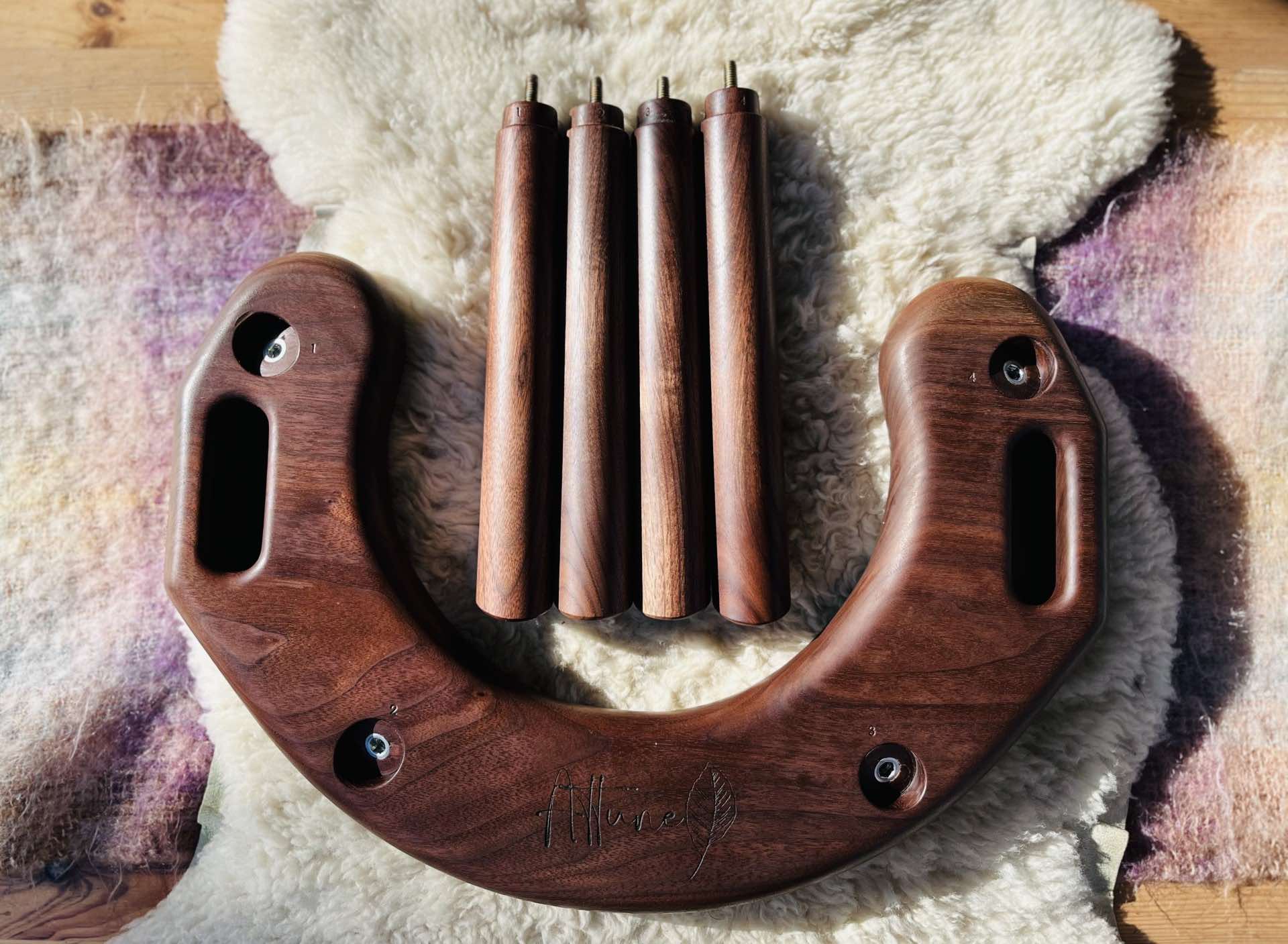 Half moon, u-shaped stool. Disassembled. Showing the underside with 4 stool legs placed nearby.